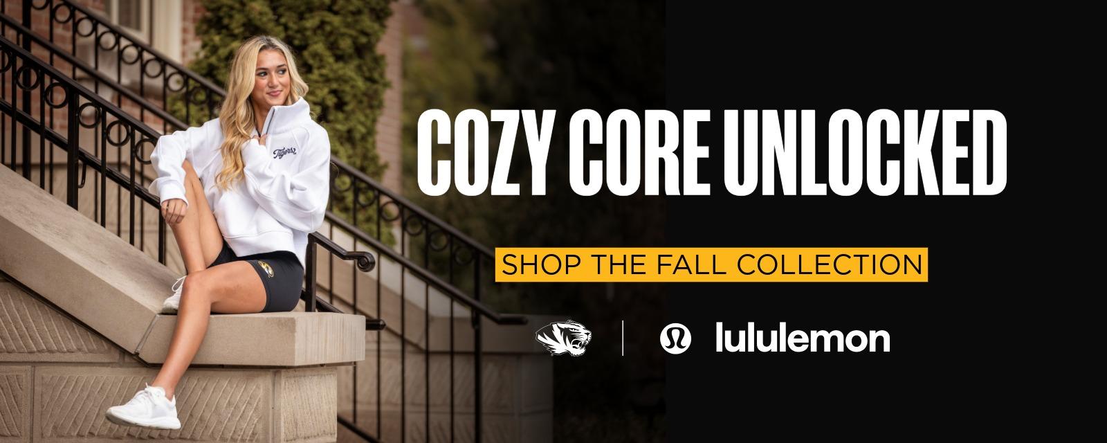 Young woman wearing white hoodie and black shorts with Mizzou logo sits on stone stairway, smiling. Text reads: Cozy Core Unlocked. Shop the Fall Collection. Lululemon and Mizzou logos appear on the right.